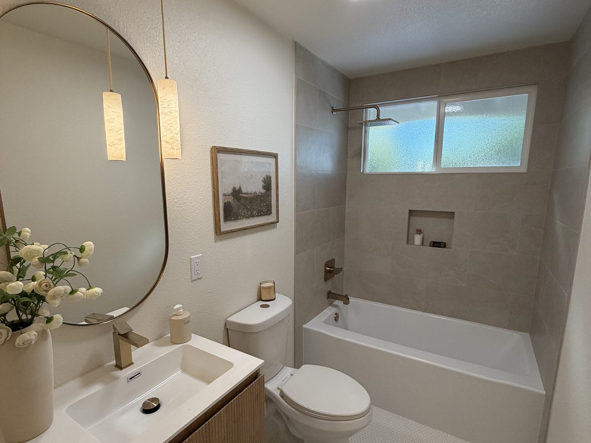 Bathroom remodel with a tub, tiled surround and penny tile floor