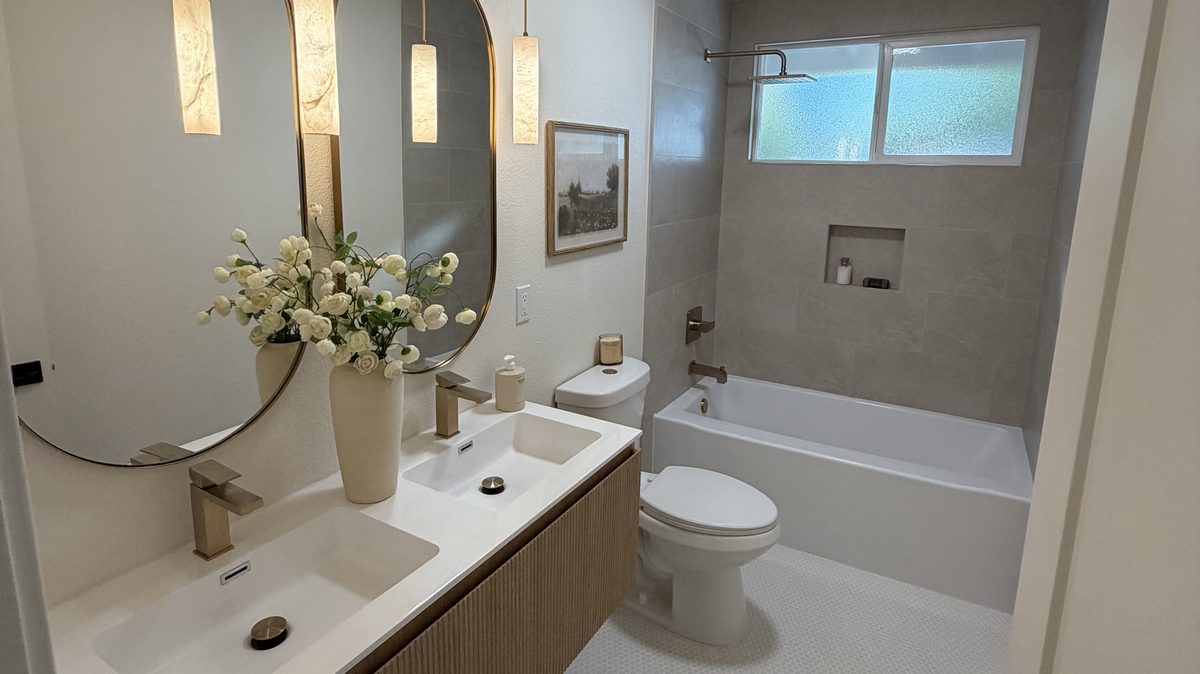 Bathroom remodel by RNDLine Construction — floating vanity and tiled tub surround
